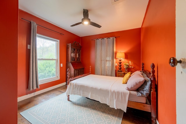 bedroom with ceiling fan, wood finished floors, and baseboards