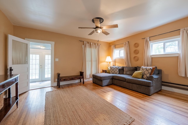 living room with wood finished floors, ceiling fan, french doors, and a baseboard heating unit