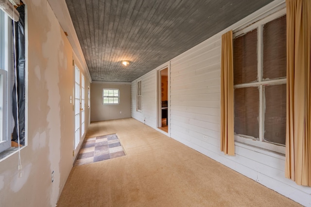 spare room featuring wooden walls, wooden ceiling, french doors, and carpet floors