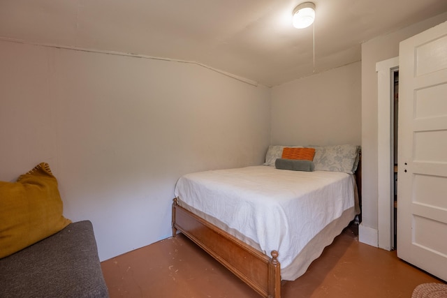 bedroom with concrete floors and vaulted ceiling