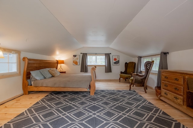bedroom with light wood-style flooring and vaulted ceiling