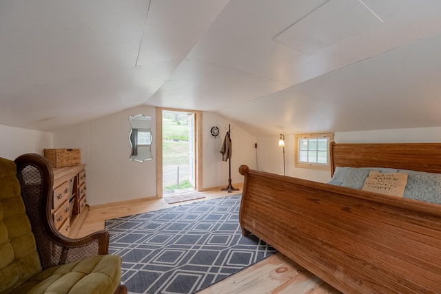 bedroom with lofted ceiling and wood finished floors