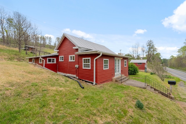 view of property exterior with a yard and entry steps