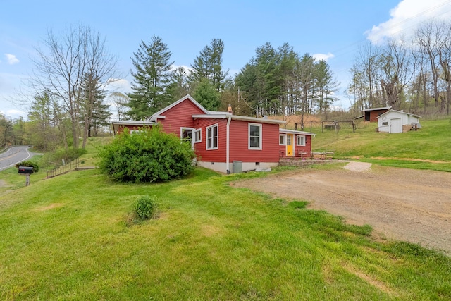 exterior space with crawl space, an outdoor structure, a yard, a shed, and driveway