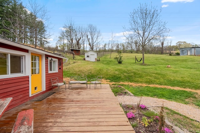 wooden deck featuring an outbuilding, a shed, and a yard