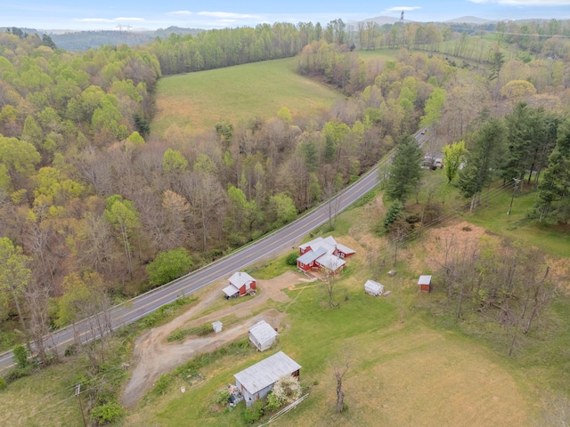 birds eye view of property featuring a rural view and a wooded view