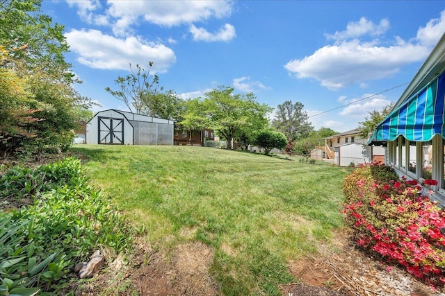 view of yard featuring a storage shed and an outbuilding