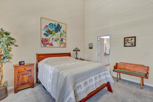 carpeted bedroom featuring baseboards and ensuite bathroom