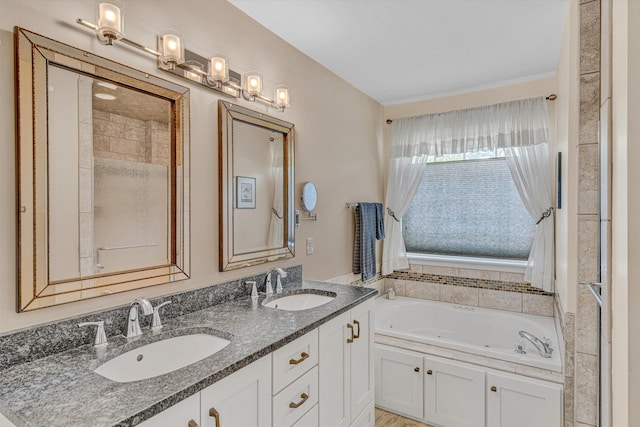full bathroom featuring a sink, a whirlpool tub, and double vanity