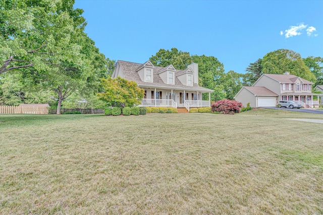 view of front of property with a garage, fence, covered porch, and a front yard