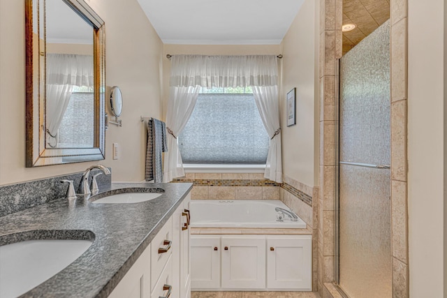 bathroom with a garden tub, a sink, double vanity, and a shower stall