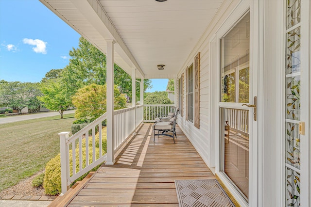 wooden deck with covered porch and a yard
