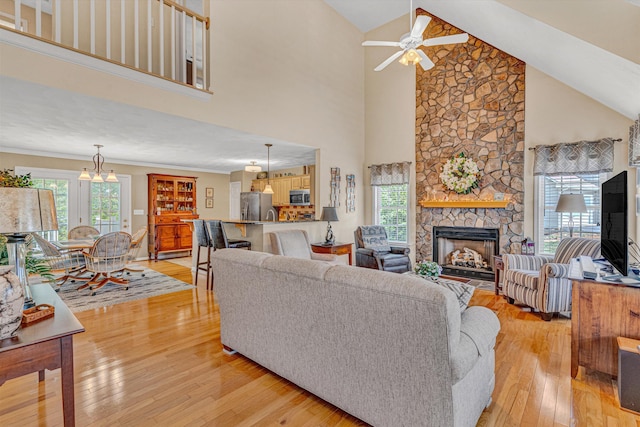 living area featuring light wood-style floors, high vaulted ceiling, ceiling fan, and a wealth of natural light