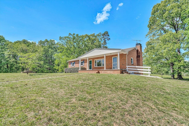 single story home with brick siding, a front lawn, and a chimney