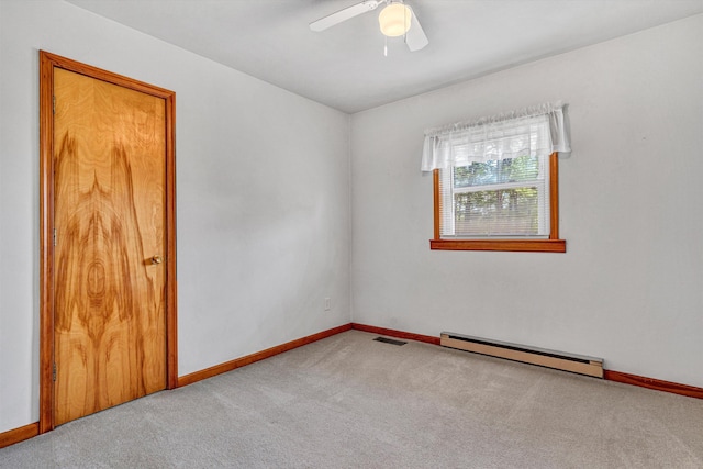 empty room featuring ceiling fan, visible vents, baseboard heating, carpet floors, and baseboards