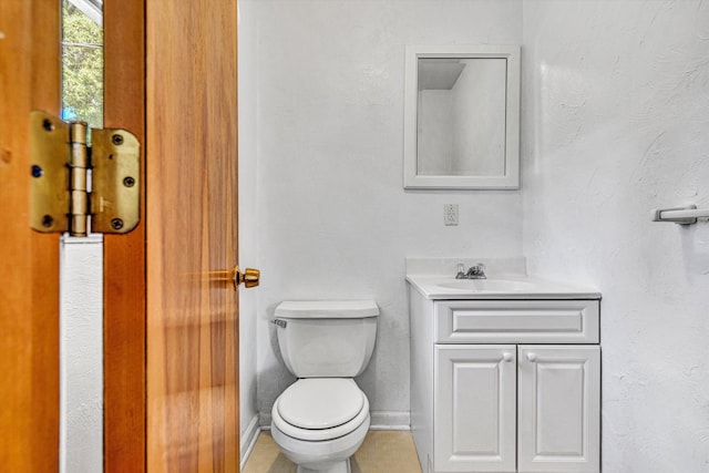 half bath featuring toilet, baseboards, and vanity
