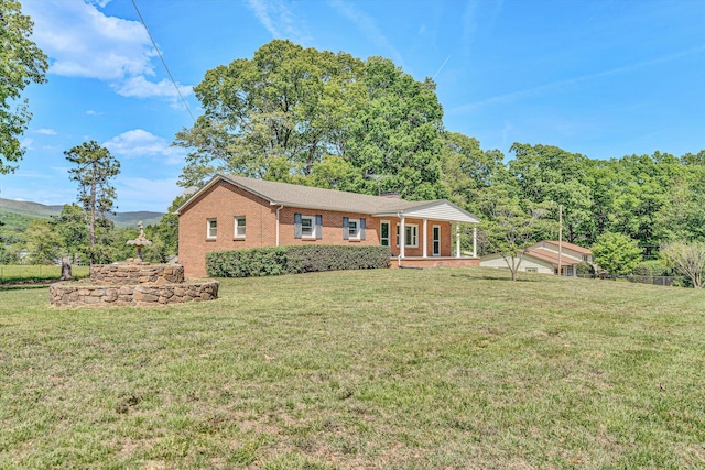 ranch-style home with a porch, brick siding, and a front lawn