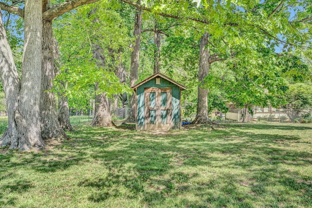 view of yard featuring fence, an outbuilding, and a storage unit