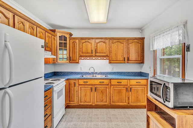 kitchen featuring a sink, under cabinet range hood, brown cabinets, and white appliances