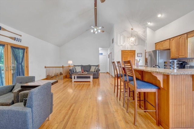 1165 Joffrey Dr, Huddleston, VA 24104 - kitchen featuring freestanding refrigerator, open floor plan, a breakfast bar area, a ceiling fan, and high vaulted ceiling