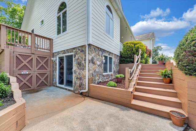 1165 Joffrey Dr, Huddleston, VA 24104 - rear view of house with stone siding, stairs, and a patio