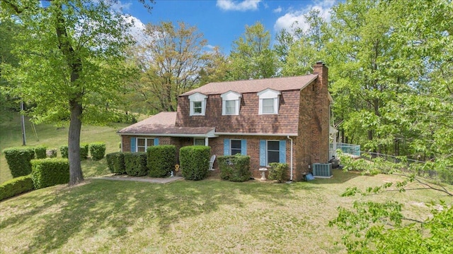 colonial inspired home with central AC, a gambrel roof, a front lawn, brick siding, and a chimney
