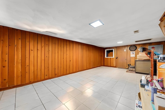 office area with wooden walls, tile patterned flooring, and visible vents