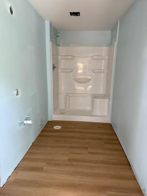 full bathroom featuring wood finished floors and a shower