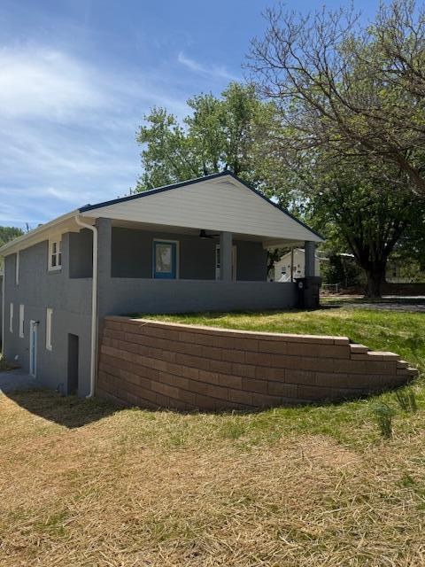 exterior space with stucco siding and a yard