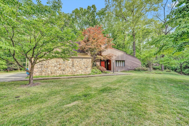 view of front facade with stone siding and a front yard