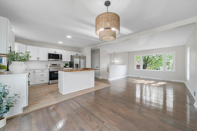 kitchen featuring wood counters, a chandelier, stainless steel appliances, baseboards, and light wood-type flooring