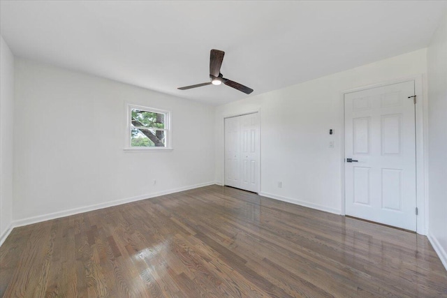 unfurnished bedroom featuring a closet, a ceiling fan, baseboards, and wood finished floors