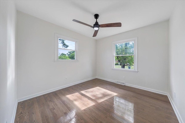 spare room featuring visible vents, baseboards, and wood finished floors