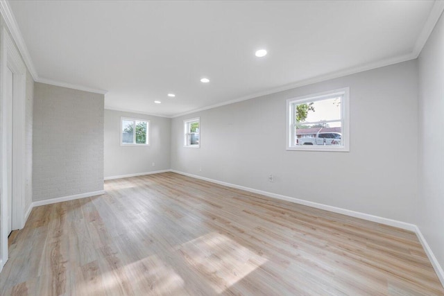 empty room with crown molding, baseboards, and light wood finished floors