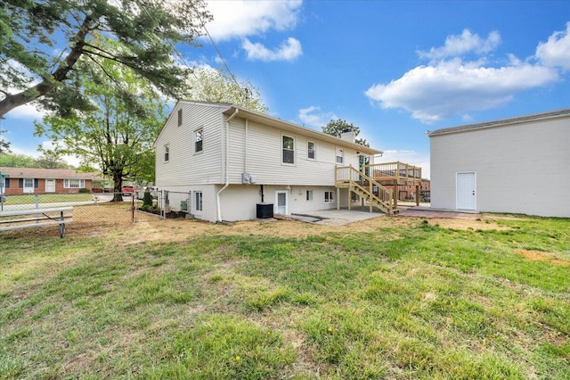 rear view of house with fence, a wooden deck, stairway, a chimney, and a yard