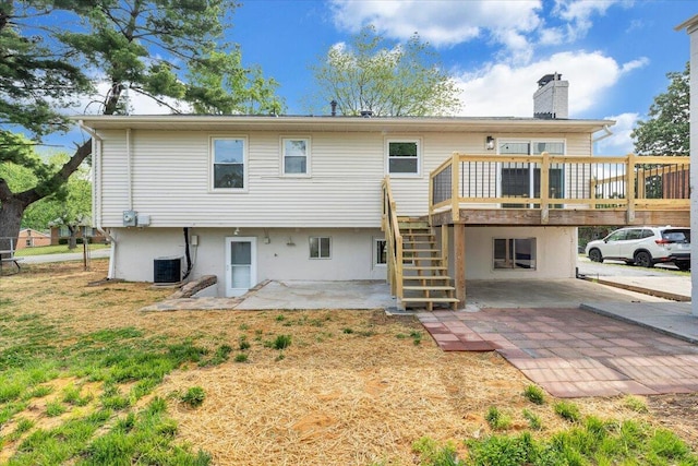 rear view of house featuring stairs, a deck, a chimney, cooling unit, and a patio area