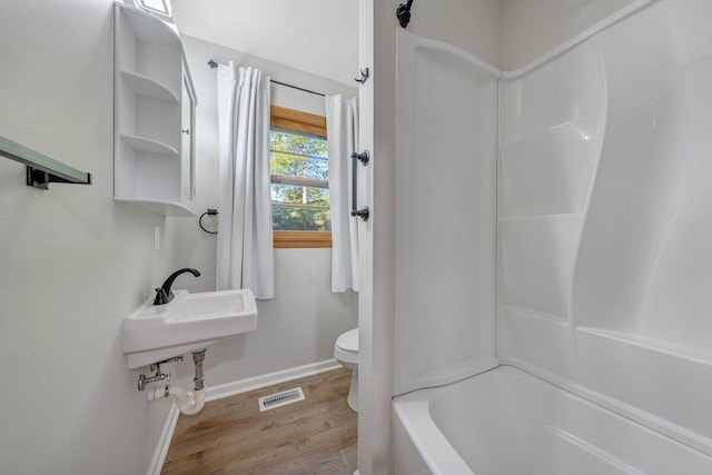 bathroom featuring visible vents, wood finished floors, a sink, baseboards, and toilet