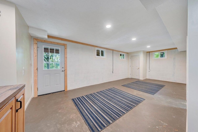 interior space with concrete block wall and recessed lighting