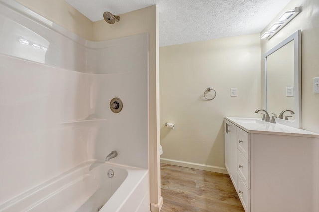 bathroom with vanity, wood finished floors, toilet, baseboards, and shower / bathing tub combination