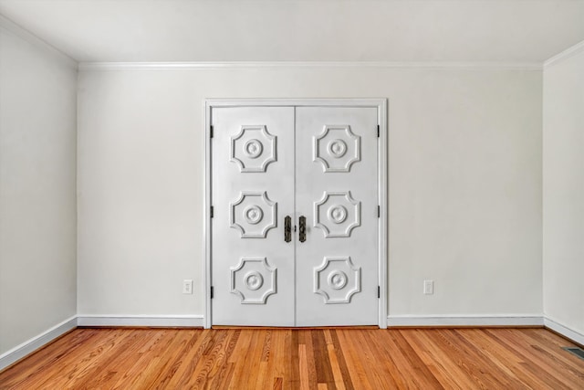 interior details featuring baseboards, ornamental molding, wood finished floors, and visible vents