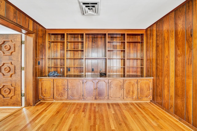 interior space with wood walls and light wood-style flooring