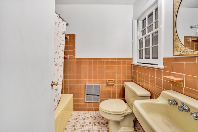 full bathroom with a sink, heating unit, toilet, and tile walls