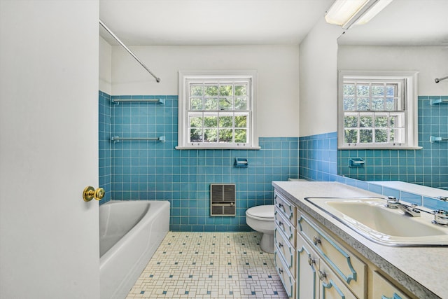 bathroom featuring toilet, tile walls, washtub / shower combination, and heating unit