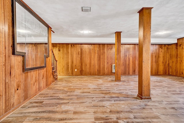 finished below grade area featuring wooden walls and wood finished floors