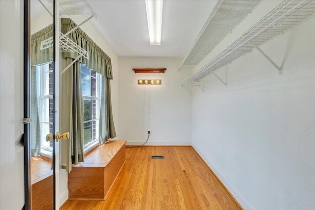 spacious closet featuring wood finished floors and visible vents