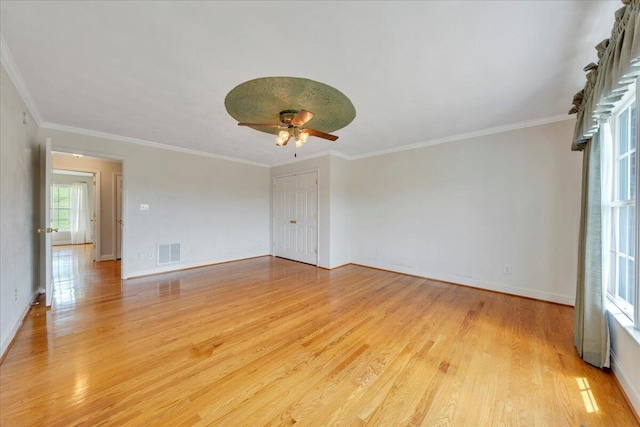 unfurnished room featuring ceiling fan, visible vents, crown molding, baseboards, and light wood finished floors