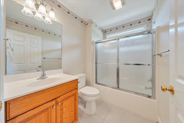 bathroom with tile patterned floors, vanity, combined bath / shower with glass door, toilet, and an inviting chandelier