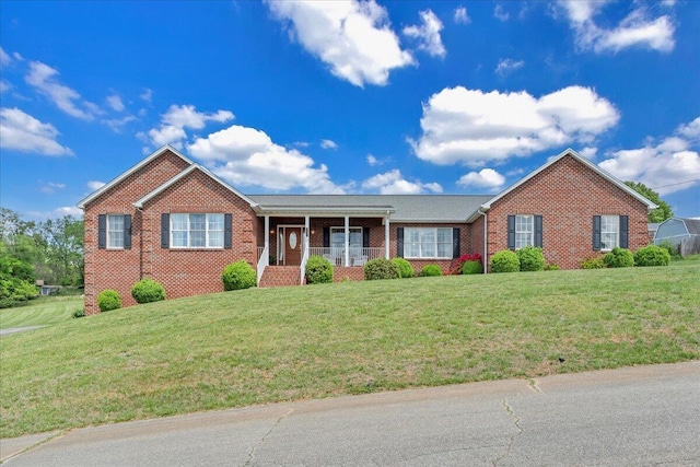 ranch-style house with brick siding, a front lawn, and a porch