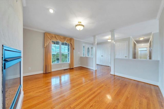 unfurnished living room featuring ornate columns, baseboards, ornamental molding, and light wood-style flooring