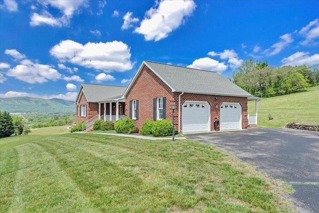 view of side of home featuring brick siding, a garage, aphalt driveway, and a lawn